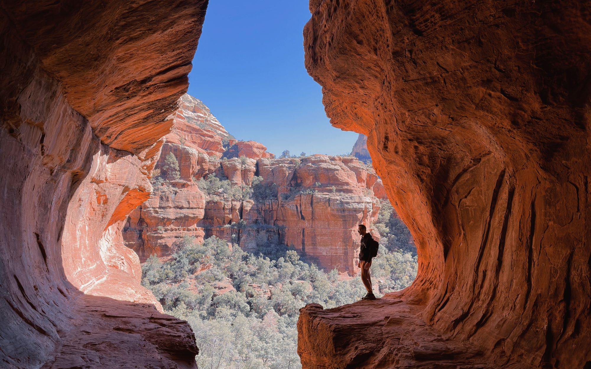Arizona red rock cave window framing a wide desert view